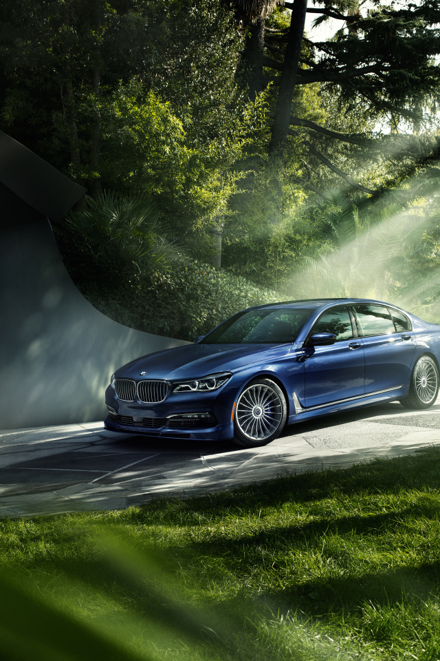 Синий автомобиль BMW 7 Series в лучах солнца 