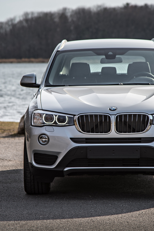 Серебристый автомобиль BMW X3 у водоема 