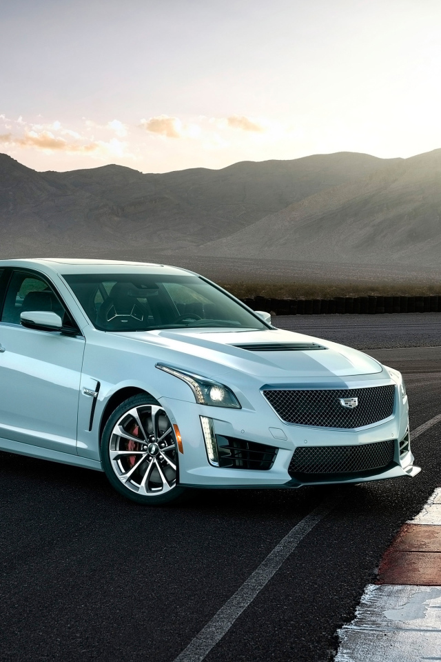Белый автомобиль Cadillac CTS-V Glacier Metallic Edition, 2018 на фоне гор