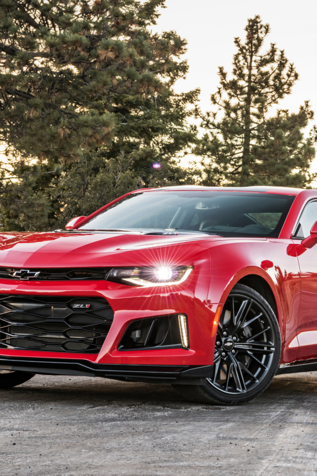 Красный автомобиль Chevrolet Camaro ZL1 на фоне леса 