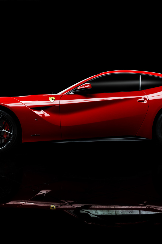 Красный спортивный автомобиль Ferrari F12 berlinetta на черном фоне