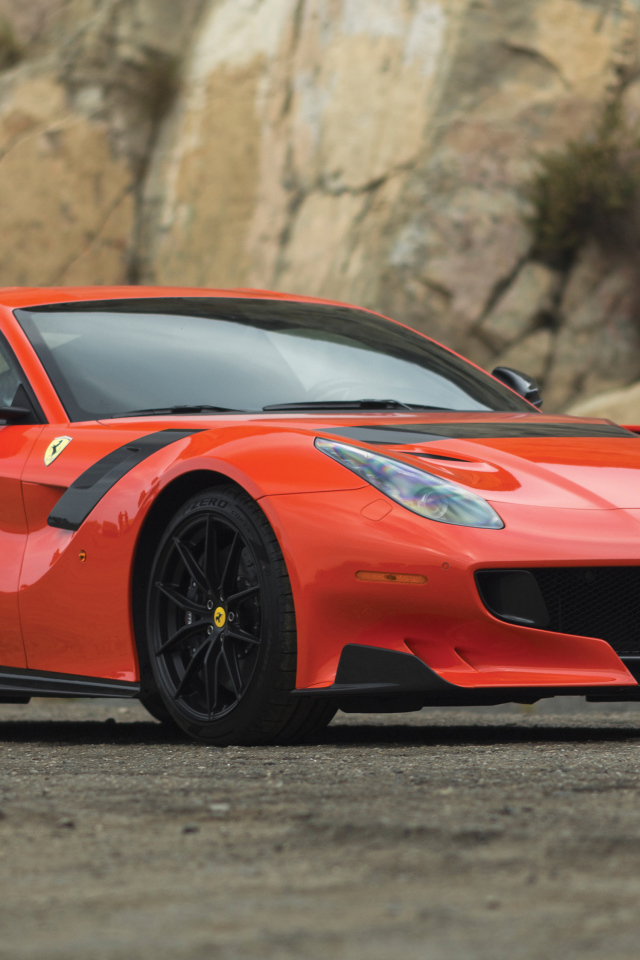 Красный спортивный автомобиль Ferrari F12tdf, 2017 у скалы
