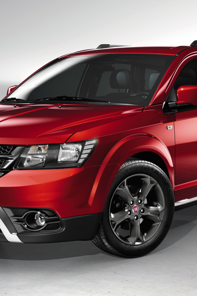 Красный автомобиль внедорожник Fiat Freemont Cross на сером фоне