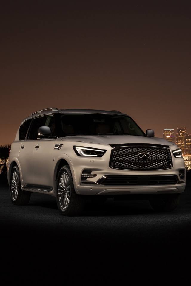 Автомобиль Infiniti QX80 2018 на фоне ночного города