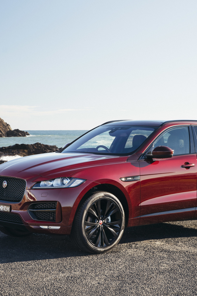 Бордовый автомобиль Jaguar F-Pace на фоне океана