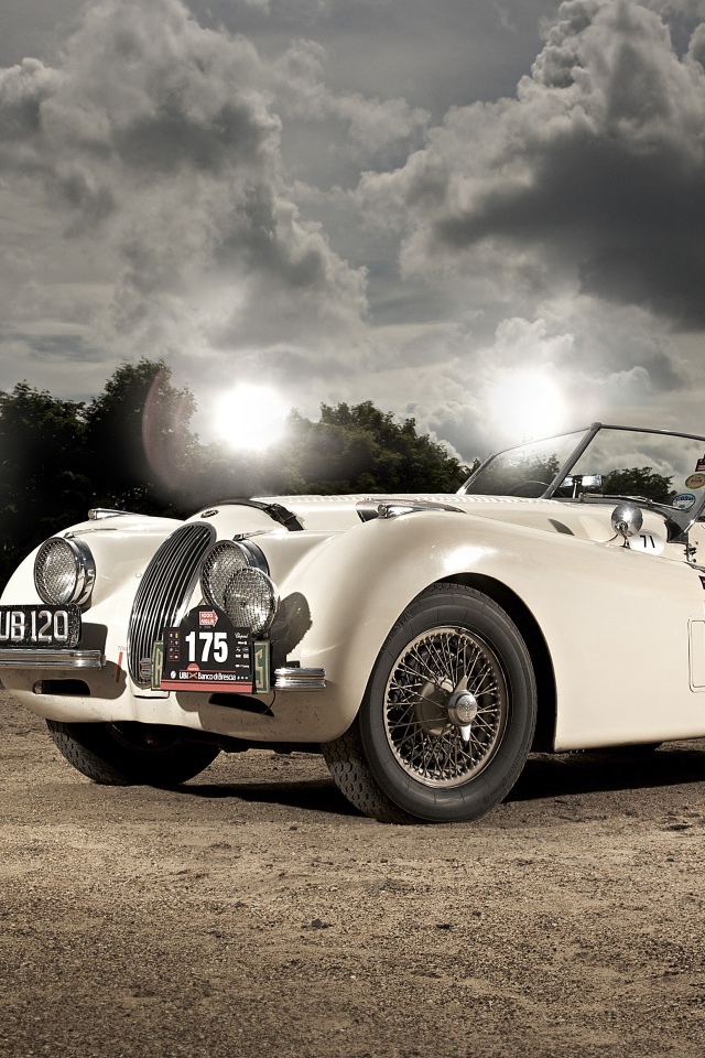 Белый спортивный ретро автомобиль Jaguar XK120, 1950 года