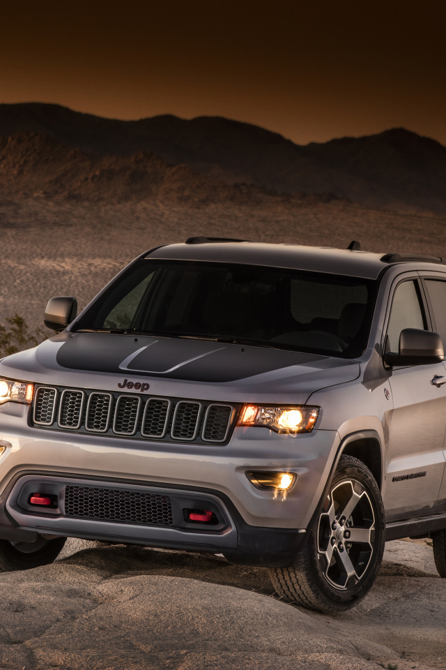 Серебристый внедорожник Jeep Grand Cherokee в пустыне 