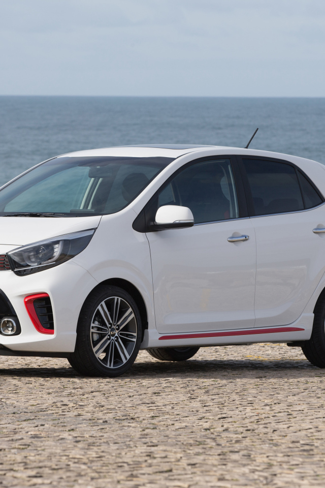 Белый автомобиль KIA Picanto GT Line, 2017 на фоне океана 