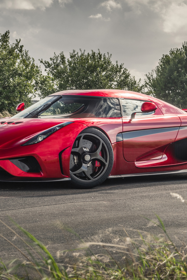 Красный спортивный автомобиль Koenigsegg Regera на дороге