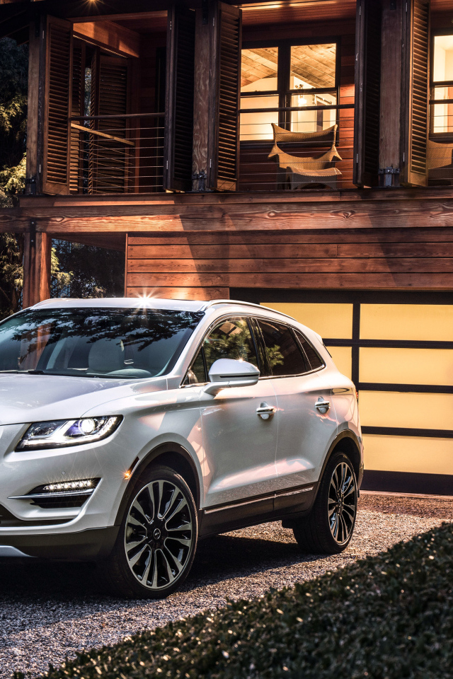 Серебристый автомобиль Lincoln MKC, 2019 у ворот гаража