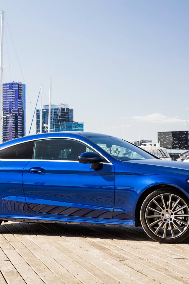 Синий автомобиль Mercedes-Benz C205 на фоне города