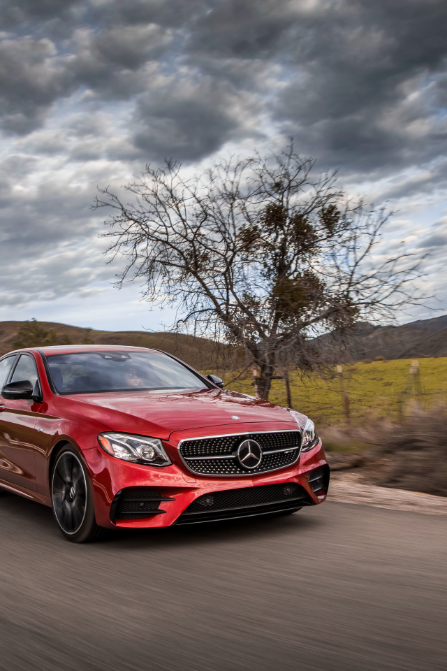 Стильный красный автомобиль Mercedes-Benz E-Class на фоне неба 