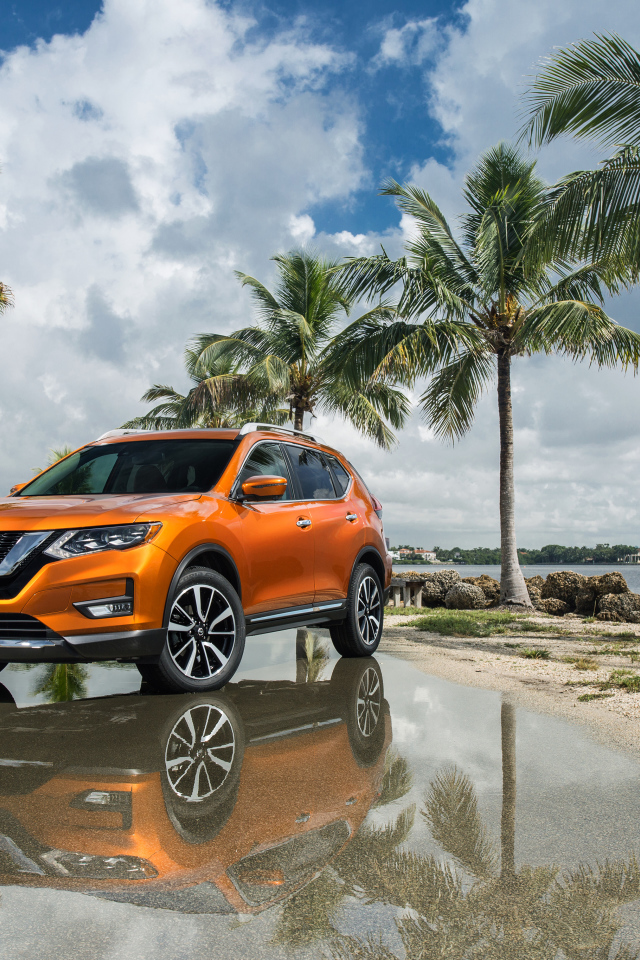 Оранжевый внедорожник Nissan Rogue на фоне пальм