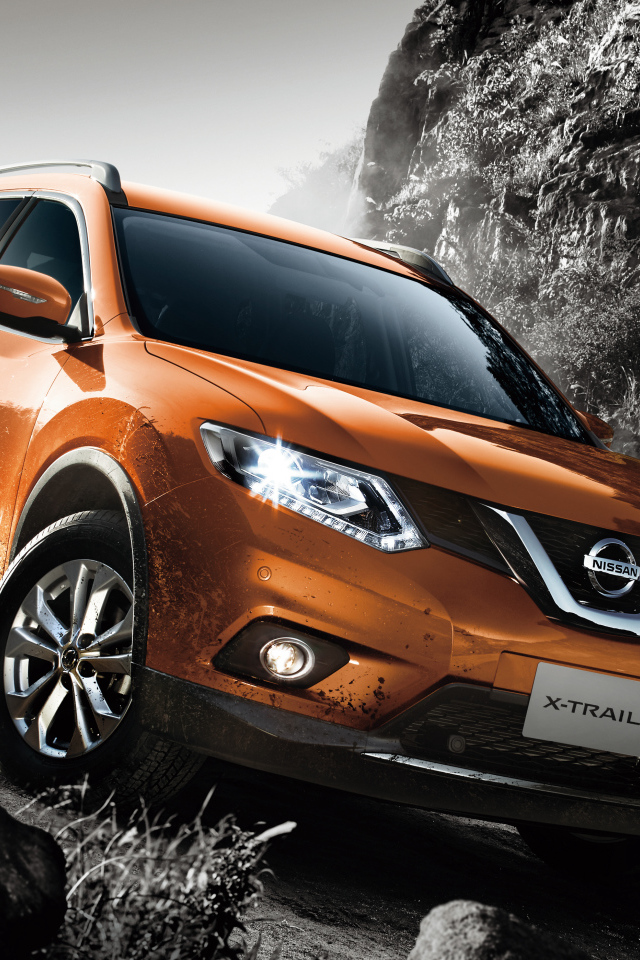 Оранжевый автомобиль Nissan X-Trail на размытой дороге 