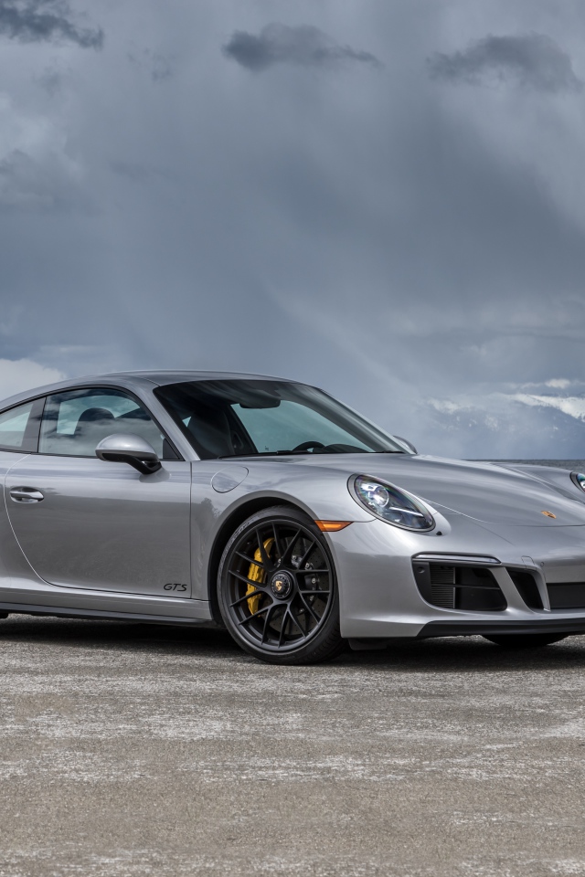 Серебристый автомобиль Porsche 911 Carrera 4 GTS Coupe на фоне грозового неба