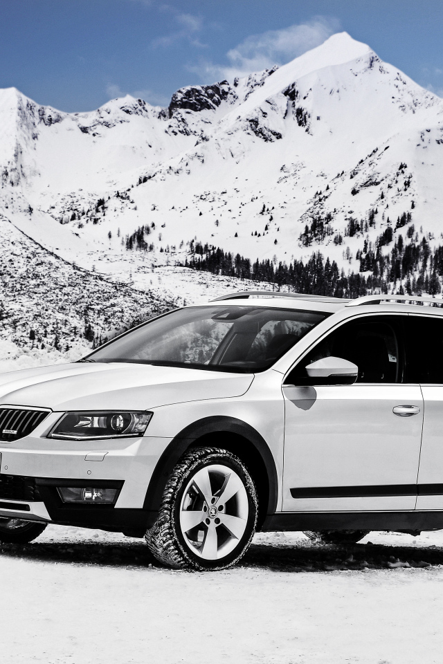 White car Skoda Octavia on a background of snow-capped mountains