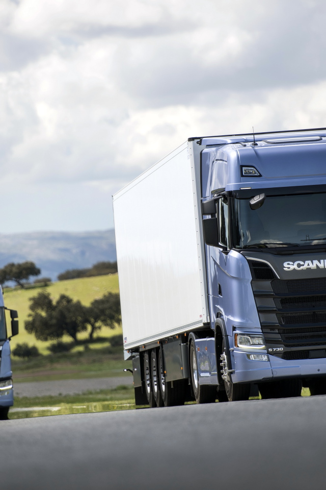 Два голубых грузовика Scania S 700 на трассе