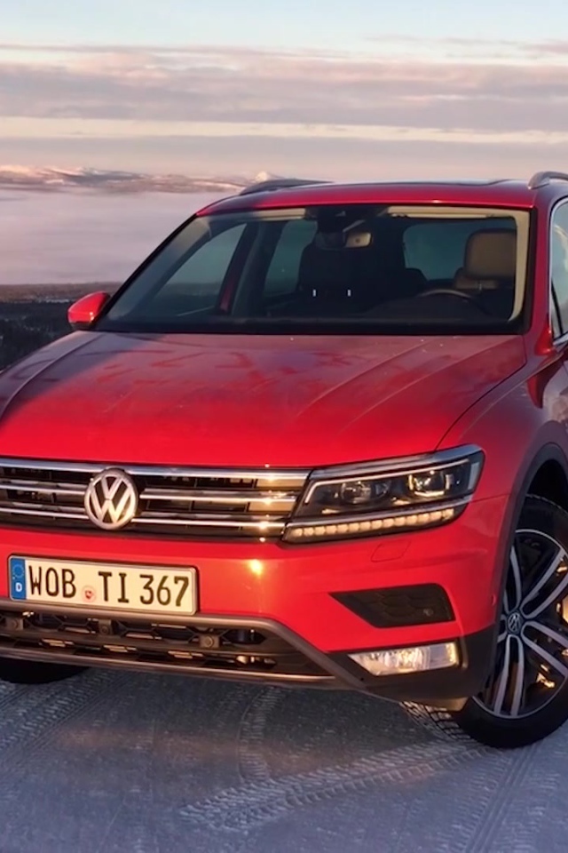 Красный Volkswagen Tiguan 2017 года на заснеженной трассе 