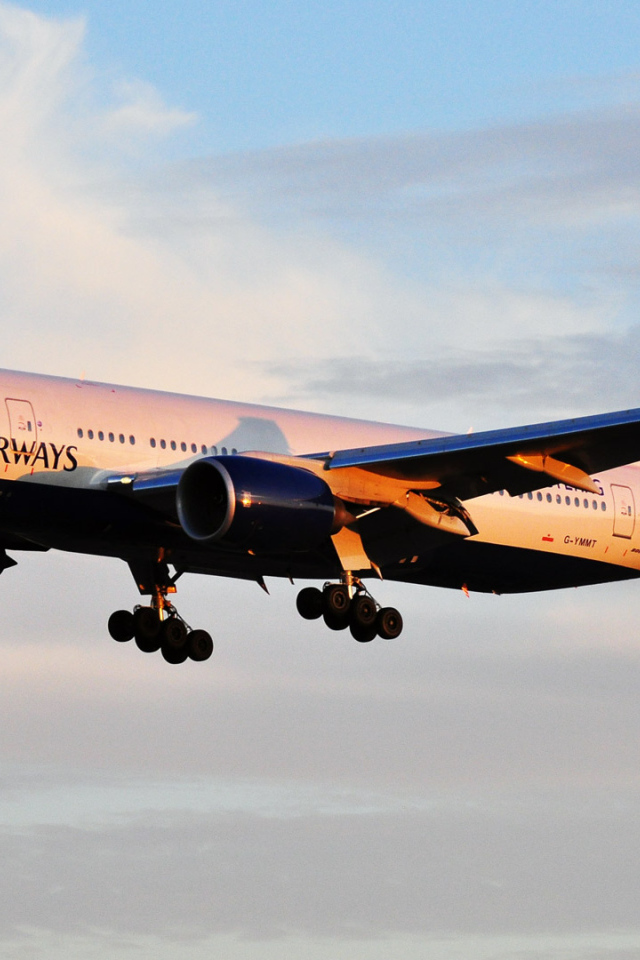 Boeing 777 of British Airways is flying at sunrise
