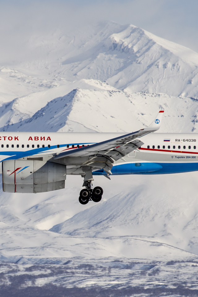 Самолет ТУ 204-300 авиакомпании Владивосток Авиа пролетает над горами Алтая 