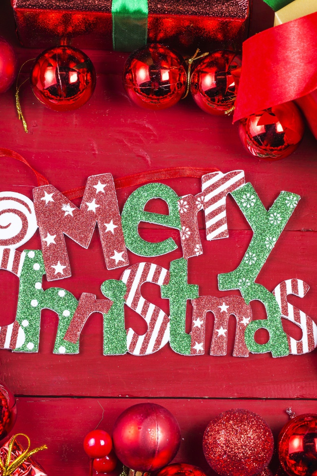 Праздничная надпись Merry Christmas на красном фоне с игрушками и подарками