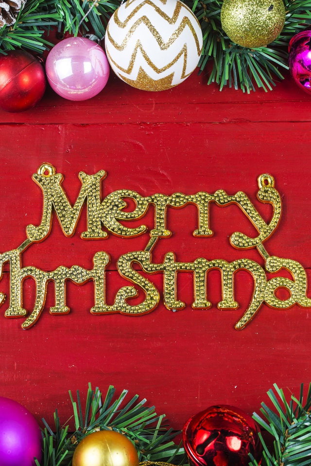 Надпись Merry Christmas на красном фоне с елочными игрушками на Рождество