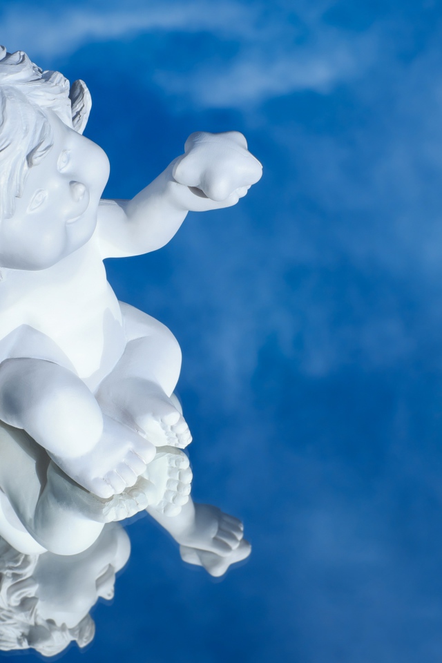 Маленькая статуя купидона отражается в голубой поверхности