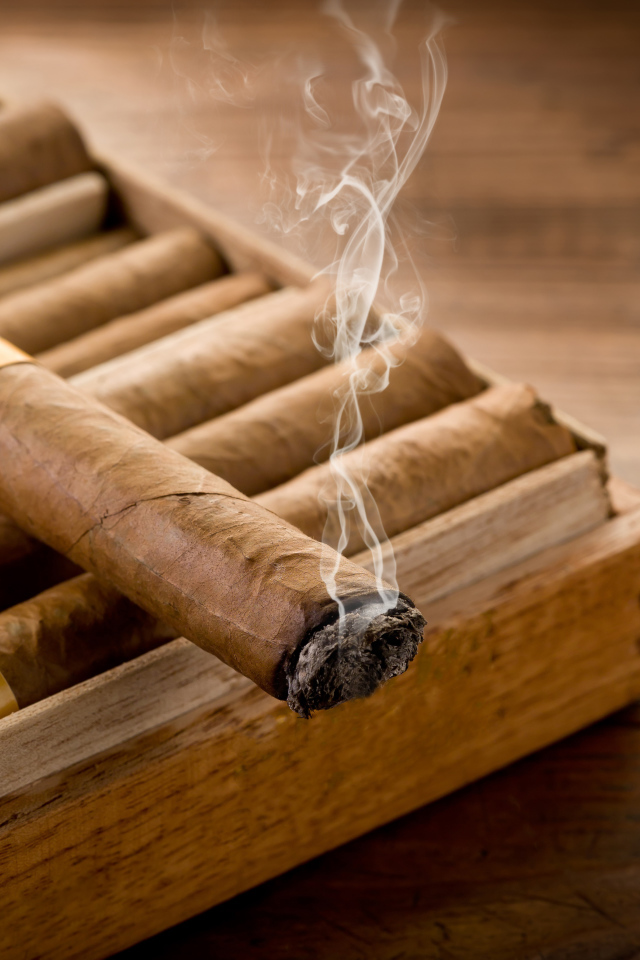Дымящаяся сигара на столе 