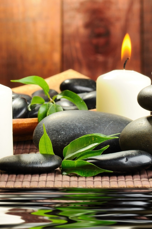 Черные камни дзен с двумя горящими свечами