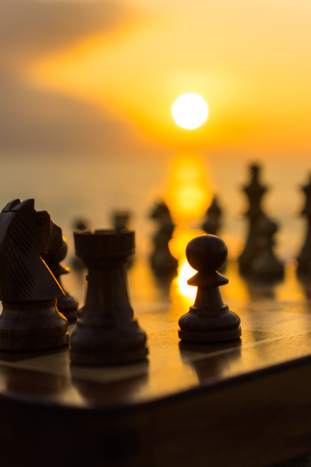 Шахматная доска с шахматными фигурами на закате солнца