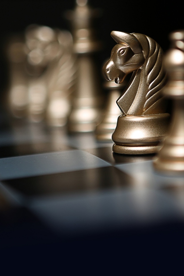 Золотые шахматные фигуры на шахматной доске