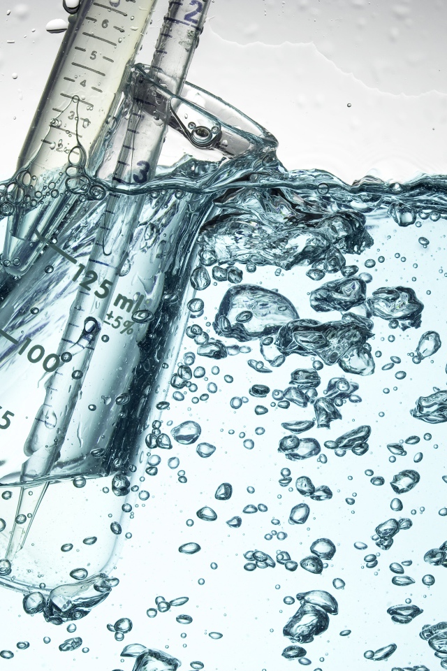 Измерительная чашка в воде с пузырями 