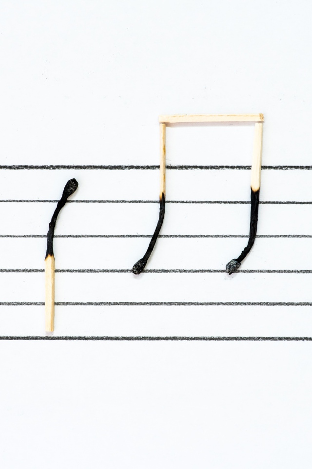 Ноты из сгоревших спичек на белом фоне