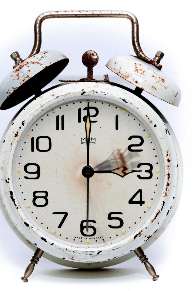 Старый будильник с большим циферблатом на белом фоне