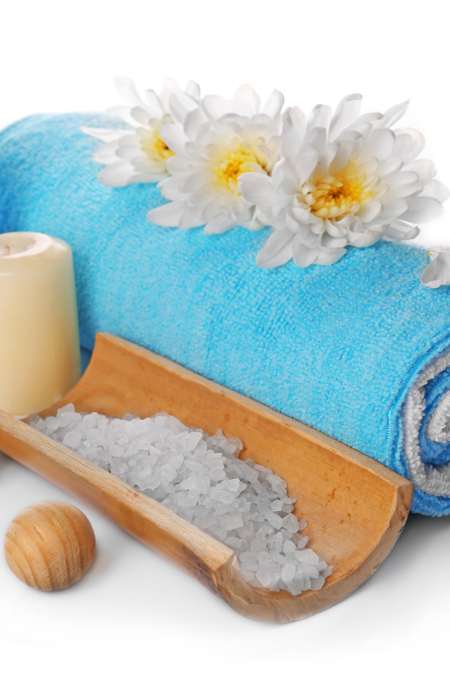 Полотенце, свечи, соль и цветы хризантемы на белом фоне