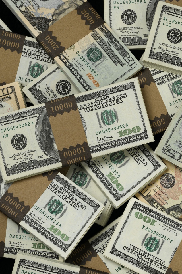 Много пачек купюр по сто долларов
