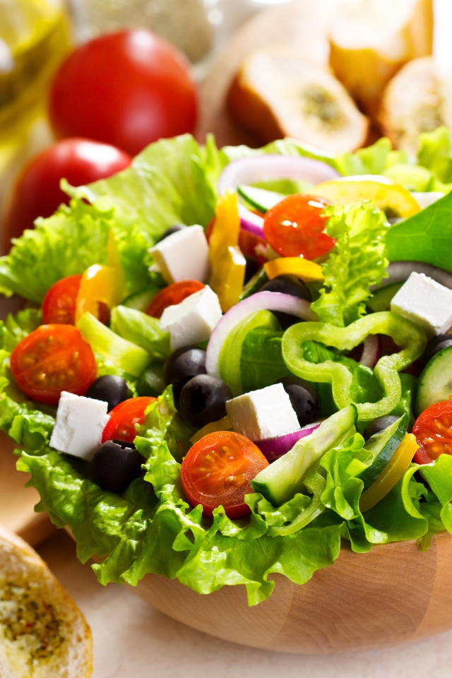 Аппетитный Греческий салат на тарелке с листьями салата