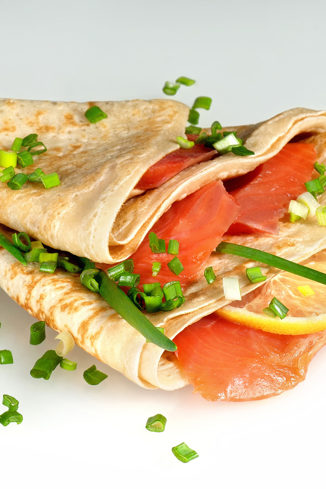 Аппетитный блин с красной рыбой и зеленым луком