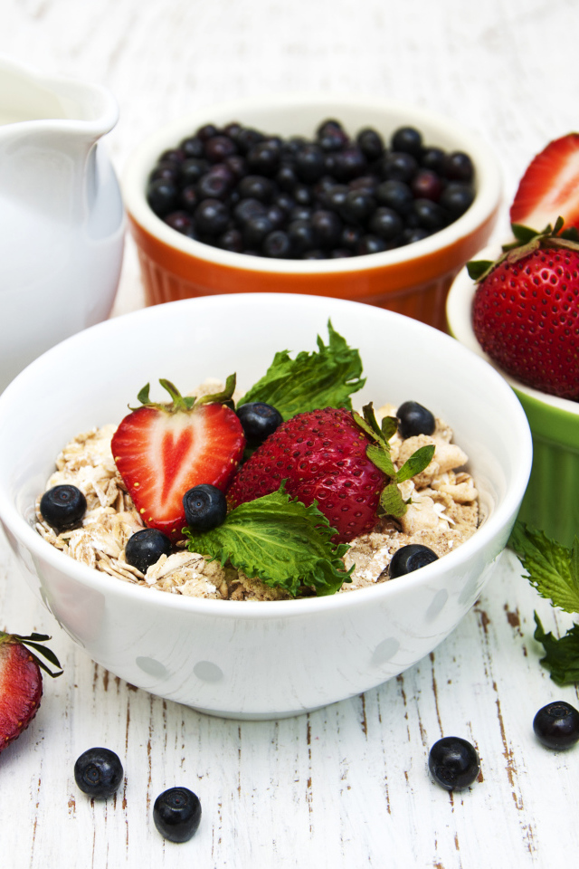 Ягоды клубники и черники на завтрак с овсяными хлопьями