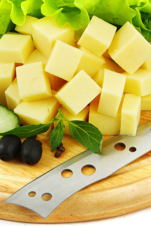 Сыр нарезанный кубиками на разделочной доске