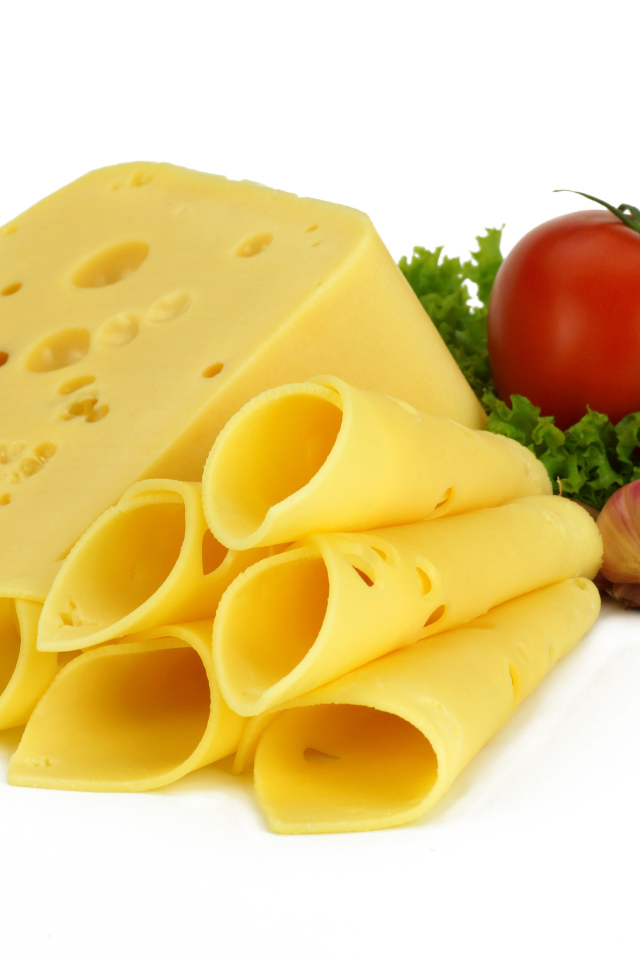 Сырная нарезка с помидором, листьями салата и чесноком на белом фоне