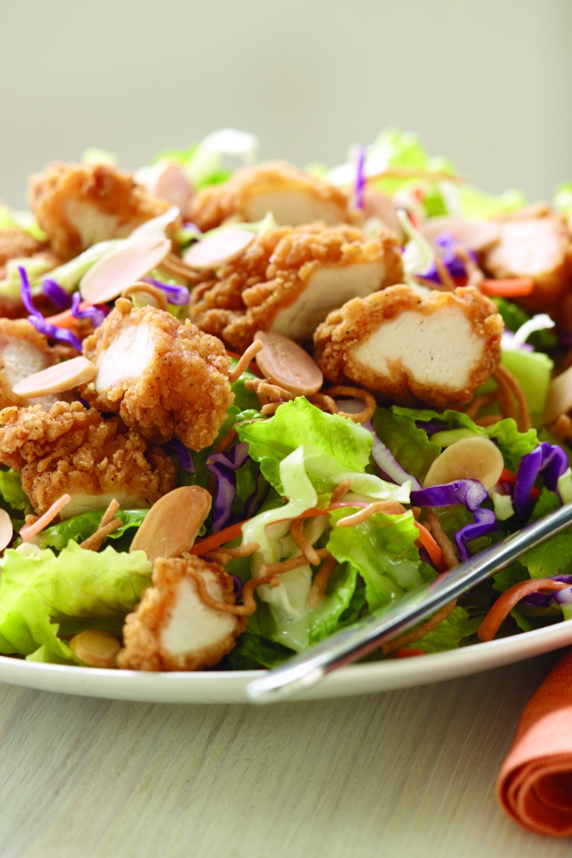 Куриный салат с орехами и капустой на тарелке