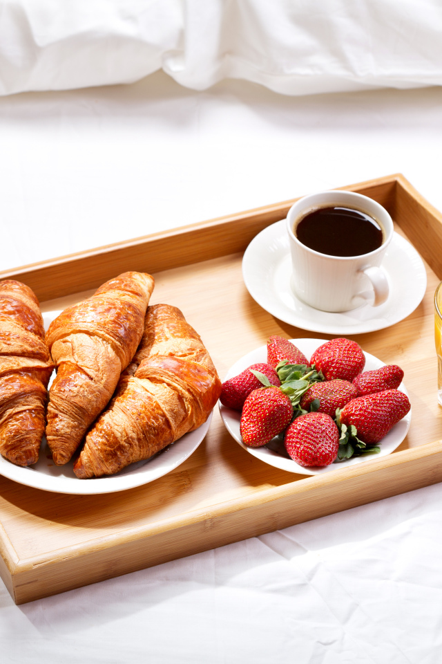 Круассаны, клубника, апельсиновый сок и кофе на завтрак