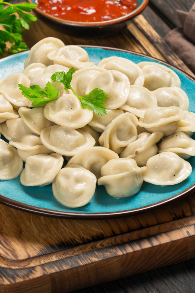 Вкусные пельмени на голубой тарелке 