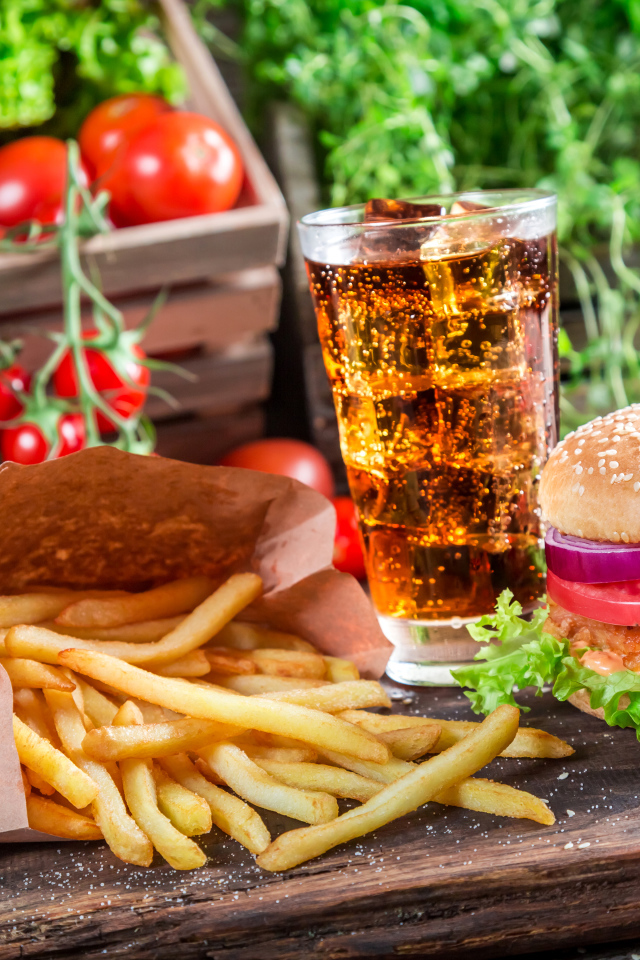 Картофель фри, пиво и сэндвич на столе 