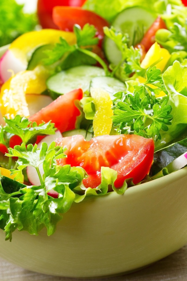 Салат из свежих овощей с зеленью на столе