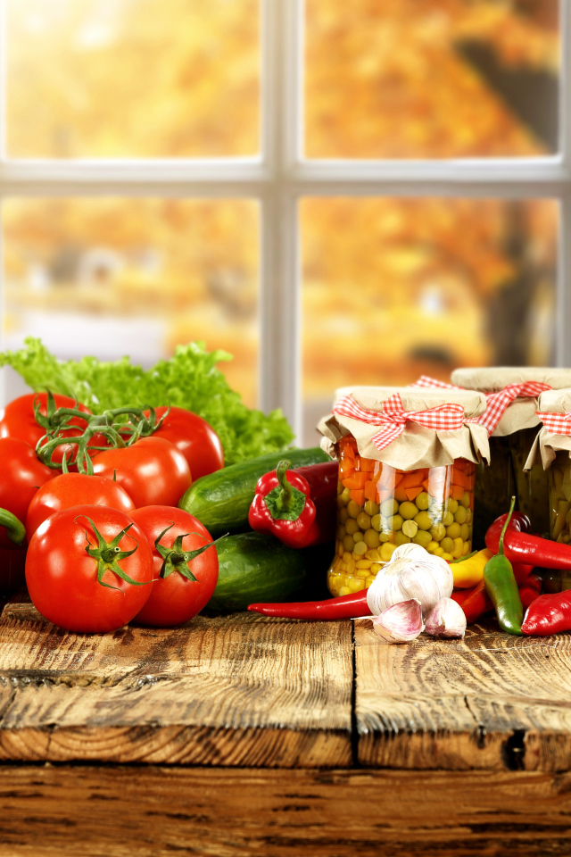 Свежие овощи и зимние заготовки на столе 