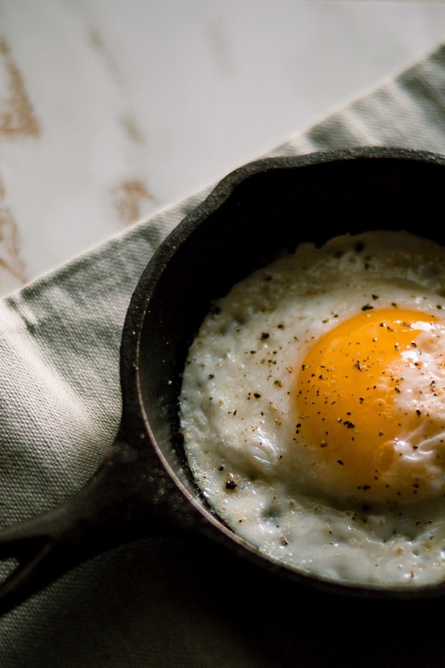 Яичница глазунья на столе в маленькой сковороде