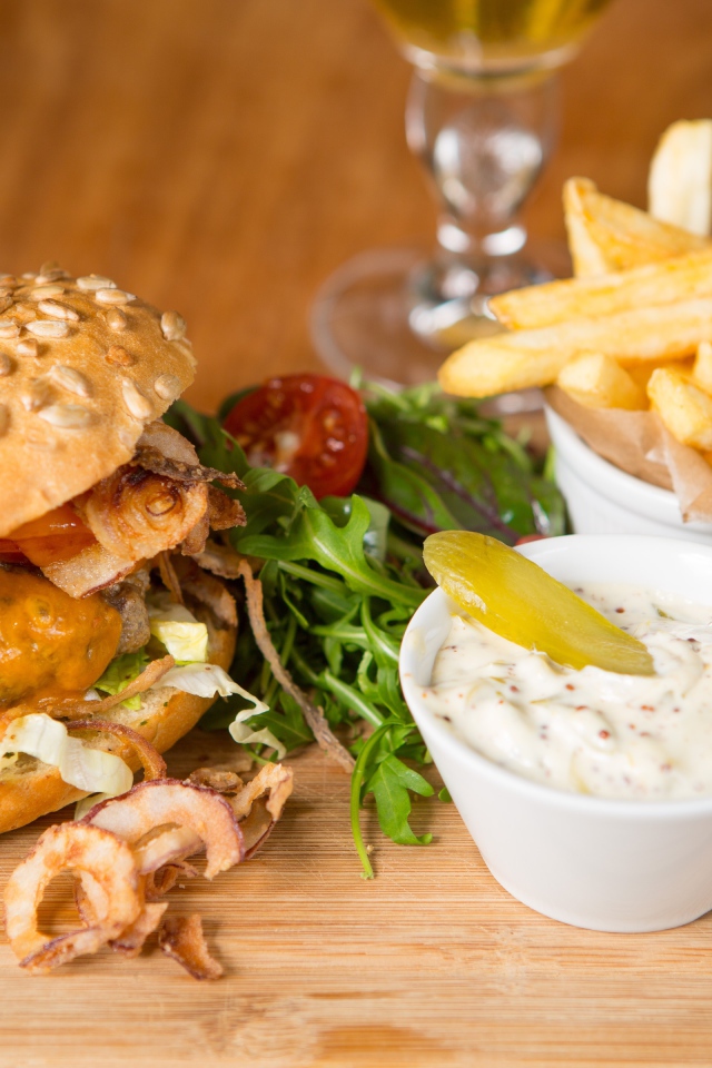 Гамбургер и картошка фри на столе с соусом