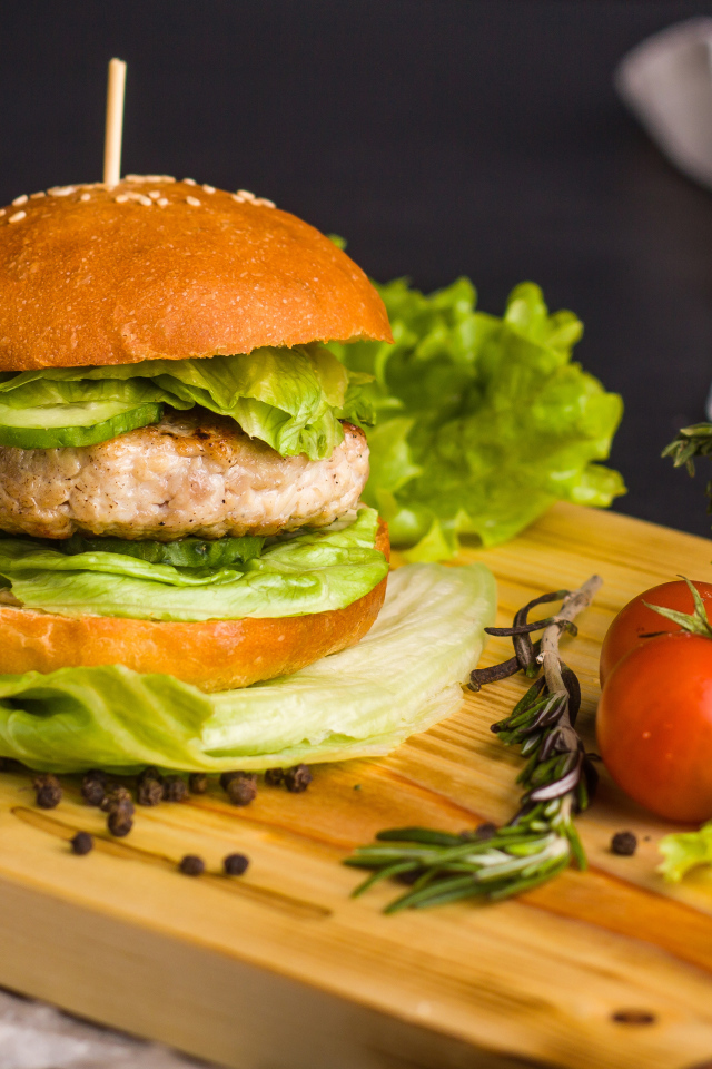 Гамбургер с зеленью на разделочной доске  